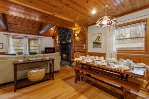 a dining room with a table and a couch at Lucky Log Cabin Hottub fireplace 12min to Mt Snow in Wardsboro