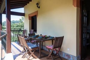 a table and chairs on a patio with a balcony at Casa vacacional La Casa de Otto in Llanes