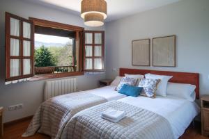 a bedroom with a large bed with a window at Casa vacacional La Casa de Otto in Llanes