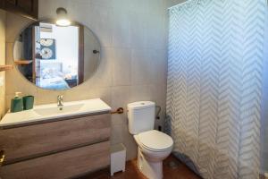 a bathroom with a toilet and a sink and a mirror at Casa vacacional La Casa de Otto in Llanes +38 photos