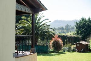 a house with a palm tree in a yard at Casa vacacional La Casa de Otto in Llanes