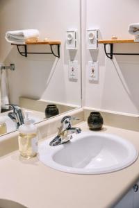 a bathroom with a white sink and a mirror at Tofino Eco Waterfront Condo in Tofino