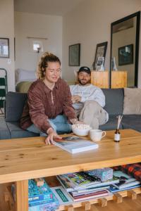 a woman sitting on a coffee table in a living room at Tofino Eco Waterfront Condo in Tofino +17 photos