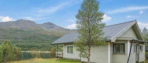 a house with a tree next to a lake at Fjord & Flame in Tromsø