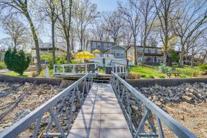 Un puente sobre una pasarela que conduce a una casa. en Bittersweet Lakefront Retreat with Hot Tub and Dock!, en Lake Ozark