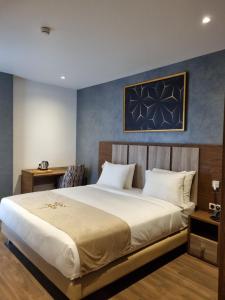 a bedroom with a large bed and a blue wall at El Aziz Inn in Cheraga +90 photos