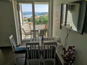 a dining room with a table and chairs and a balcony at VillaTea in Murter