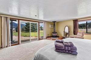 弗拉格斯塔夫Rustic Mountain Chalet with Private Studio Minutes from Snowbowl的卧室里有一张大床，配有一把椅子和一个壁炉
