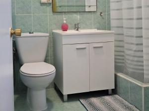 une salle de bain avec des toilettes blanches et un lavabo dans l'établissement Corinto, à Benalmádena