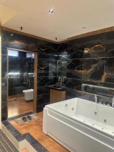 Un baño grande con bañera y lavabo. en Hotel victoria prime, en Surat