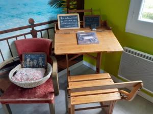 a table with a chair and a desk with a chalkboard at Le Verger in Carnas