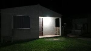 a door to a house with a light at night at Lo de Po-Ly in Chuy