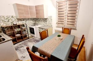 a kitchen with a table and chairs and a kitchen with a table and a table at Cvitak home in Čapljina