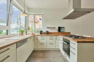 a kitchen with white cabinets and a sink at Exklusive Villa-Eggert mit Kamin & Terasse für 6 Personen im Bretten in Bretten