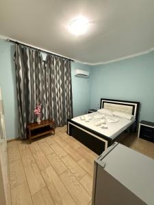 a room with a bed and a table with flowers at Villa AlMar in Sarandë