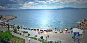a group of people on a beach near the water at Dream Apartment Rijeka 3 in Rijeka