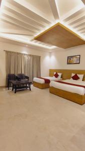 a bedroom with two beds and a desk and a couch at ST Kodai Heaven Stay in Kodaikānāl