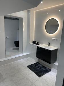 a white bathroom with a sink and a mirror at Stadtnah & und familienfreundlich in Rüsselsheim