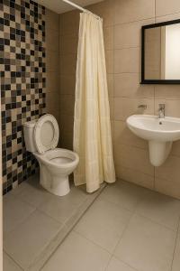 ein Badezimmer mit Toilette und Waschbecken in der Unterkunft Modern 2-room with pool, close to beach, private parking in Martil