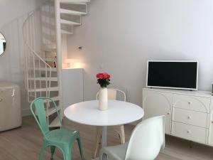 a white table with chairs and a vase with flowers at Villa Mini Romy with outdoor area in Parmain