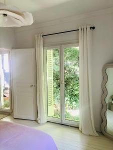 a bedroom with a bed and a large window at Villa Mini Romy with outdoor area in Parmain
