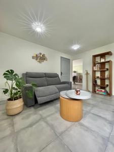 a living room with a couch and a coffee table at Cocon lumineux, tout confort in Aiglemont +3 photos