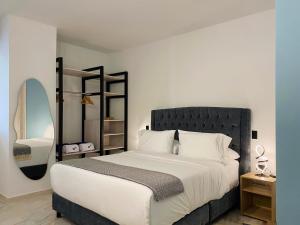 a bedroom with a large bed and a mirror at Muralla by Wynwood House in Cartagena de Indias