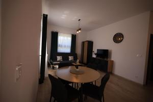 Una sala de estar con una mesa y sillas y un sofá. en Apartamenty Stronie - Polna Przystań, en Stronie Śląskie