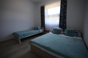 Un dormitorio con dos camas y una ventana en Apartamenty Stronie - Polna Przystań, en Stronie Śląskie