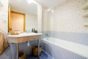 a bathroom with a sink and a bath tub at Casa Goya Vírgenes in Zaragoza