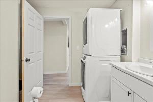 La cuisine blanche est équipée d'un réfrigérateur et d'un évier. dans l'établissement Riverside Retreat - Renovated Home on 15 Acres!, à Janesville 27 autres photos