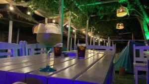 a table with a glass of wine and two drinks at La Cort & Căsuțe Camping Adults Only in Vama Veche