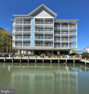 een groot appartementencomplex naast een waterlichaam bij New Construction with Beautiful Canal Views in Ocean City