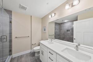 een badkamer met 2 wastafels, een toilet en een douche bij New Construction with Beautiful Canal Views in Ocean City +19 foto's