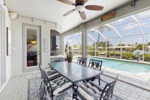eine Terrasse mit Tisch und Stühlen und einem Pool in der Unterkunft Tiffany Treasure in Cape Coral