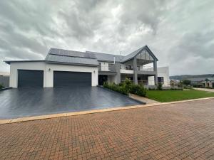 una casa con paneles solares en la parte superior de una entrada en 955 Highlands Gate Golf Estate, en Dullstroom