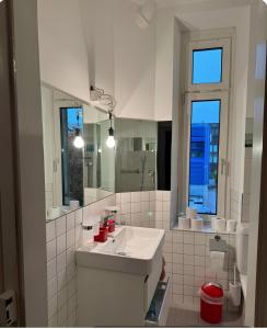 a white bathroom with a sink and a mirror at Zentrales Zimmer im 1OGC 2 Gehminuten zum Bahnhof Solothurn in Solothurn
