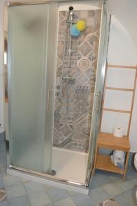 een douche met een glazen deur in een kamer bij Trullo Levante Valle d'Itria in Cisternino +13 foto's