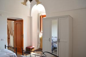 een slaapkamer met een bed en een kast met een spiegel bij Trullo Levante Valle d'Itria in Cisternino