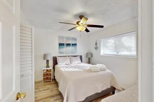 une chambre blanche avec un lit et un ventilateur de plafond dans l'établissement Hilton Head Resort 2103, à Île de Hilton-Head 64 autres photos