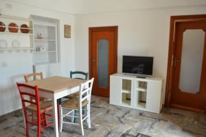 een eetkamer met een tafel en een tv bij Trullo Levante Valle d'Itria in Cisternino