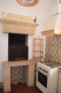 een keuken met een fornuis en een oven bij Trullo Levante Valle d'Itria in Cisternino