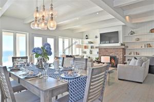 a dining room with a table and chairs and a fireplace at Villa et spa - Le coeur de la plage - Charlevoix ! in Saint-Irénée