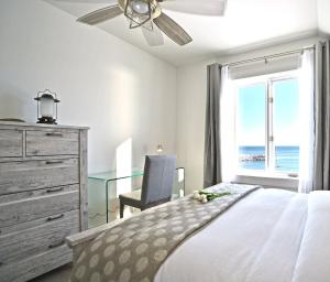 a bedroom with a bed and a desk and a window at Villa et spa - Le coeur de la plage - Charlevoix ! in Saint-Irénée +81 photos