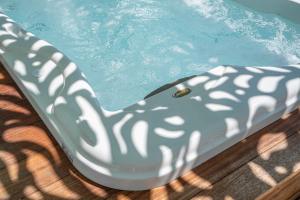 a pool with a plastic chair in the water at Grypes Deluxe Complex in Egina