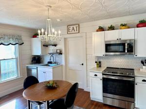 a kitchen with white cabinets and a wooden table at The Wright Choice - Cozy Spot- Near to Aviation Museum in Hickory