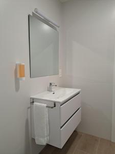 a white bathroom with a sink and a mirror at La Alegria de la Huerta Cudillero in Cudillero