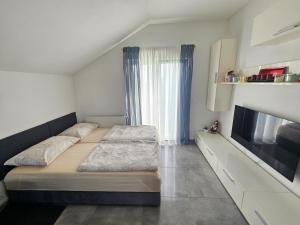 a bedroom with two beds and a large window at Apartman MAGDALENA in Sesvete
