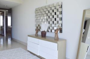a living room with a dresser and a tile wall at Beautiful Seibal Stay w Vidanta Resort Access in Nuevo Vallarta 