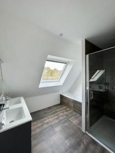 a bathroom with a shower and a sink and a window at Superbe Villa tout confort avec piscine chauffée er couverte et spa à 2 pas de la plage in Fouesnant